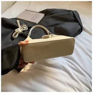 Détails de la structure du fond plat et des coutures fines du sac à main blanc crème