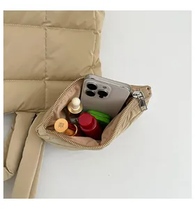 Détail du cabas matelassé kaki montrant le rangement pour téléphone et cosmétiques