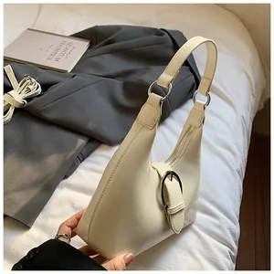 Gros plan du sac demi-lune crème avec boucle en métal argenté et fermeture éclair