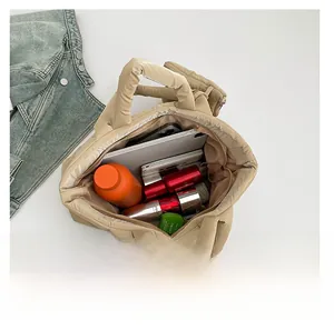 Intérieur spacieux du cabas matelassé beige avec tablette, bouteille et cosmétiques