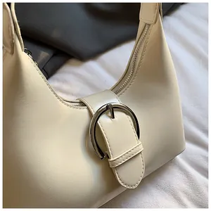 Gros plan détaillé du sac croissant ivoire avec boucle métallique ronde argentée et cuir grainé