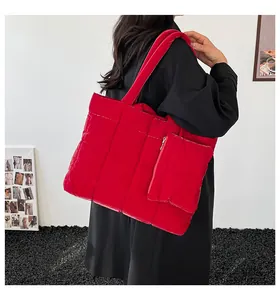 Détail du sac fourre-tout matelassé rouge avec pochette assortie à l'épaule du modèle