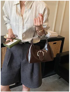 Détail du sac à main en cuir verni marron vintage avec boucle fer à cheval en argent brillant