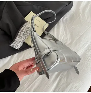 Détail du sac à bandoulière en cuir ciré argenté avec fini métallisé et œillets en métal
