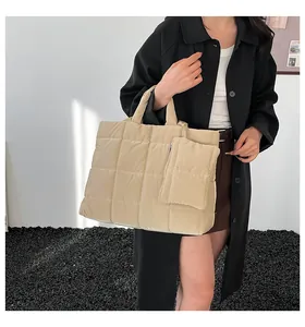 Gros plan du sac fourre-tout matelassé beige avec sa petite pochette assortie