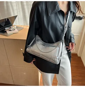 Gros plan sur un sac argenté métallisé avec texture craquelée et détails de chaîne