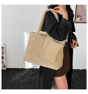 Macro-opname van beige gewatteerde shopper met borduurtextuur en klein ritszakje