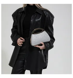 Close-up of sparkling silver sequin evening clutch bag with hollow gold metal handle