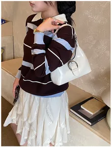 Détail d'un sac hobo blanc crème avec une boucle argentée et une finition brillante