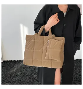 Quilted tote bag with matching small pouch in khaki puffer fabric shown on a model