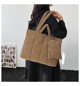 Détail d'un sac cabas matelassé kaki avec sa mini pochette zippée et coutures apparentes