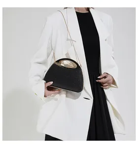 Detail of elegant black glitter evening bag with gold metal handle and chain strap