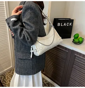 Détail du sac à bandoulière crème en similicuir brillant avec fine chaîne métallique