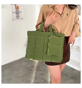 Détail du sac fourre-tout matelassé vert avec sa pochette zippée assortie en situation
