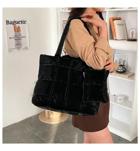 Detail van zwarte gewatteerde shopper met dubbele schouderbanden en kleine etui