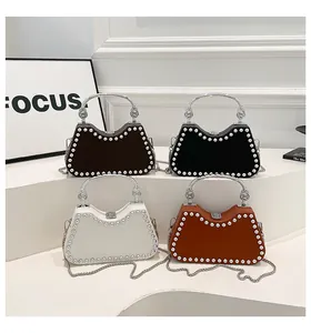 Detail of four colorful handbags with pearl trim and metallic chain handles on display