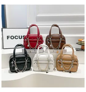 Detail of five mini top-handle bags in lychee texture leather with decorative chains