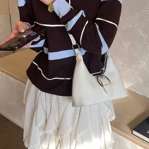Sac à bandoulière chic en cuir beige en forme de croissant avec boucle en métal argenté