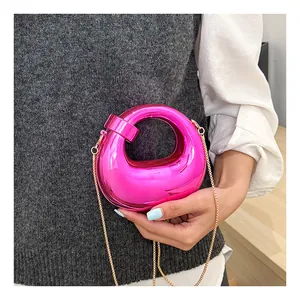 Fashionable bright pink mini crescent bag with metallic mirror finish and gold chain strap