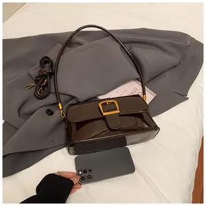 Détail du sac sous l'aisselle en cuir verni avec boucle dorée et référence de taille