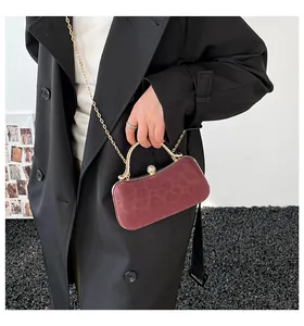 Detail of burgundy leopard embossed velvet handbag with gold frame and chain strap