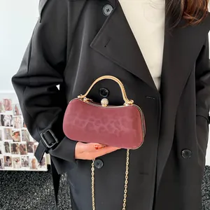 Elegant wine red velvet clutch with gold metal handle and sparkling diamond clasp