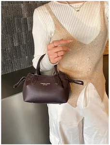 Close-up of litchi texture leather handbag with elegant drawstring and logo detail