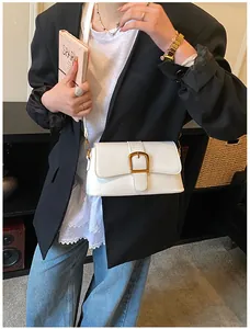 Détail d'un sac à bandoulière en cuir verni blanc avec boucle carrée dorée vintage