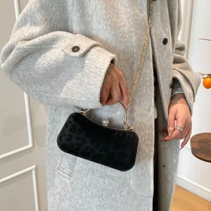 Elegant black leopard texture evening handbag with gold handle and diamond clasp