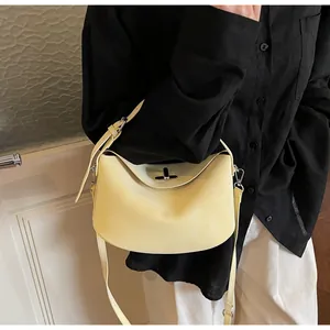 Detailed close-up of matte pale yellow leather handbag with metal turn-lock closure