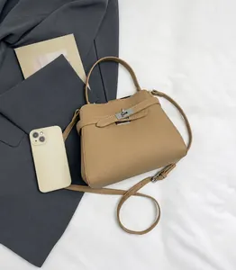 Close-up of khaki leather bucket bag showing size comparison with a smartphone