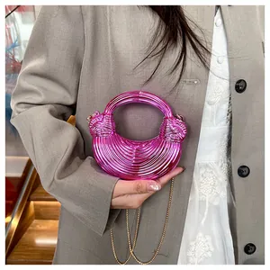 Détail du sac croissant rose métallisé avec texture et bandoulière chaîne dorée