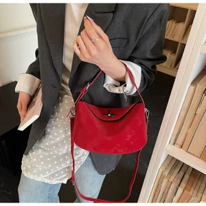 Detail of red pebbled leather shoulder bag with metallic twist lock and versatile straps