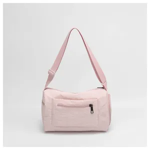 Vue détaillée du sac en nylon rose clair avec fermeture éclair et bandoulière réglable