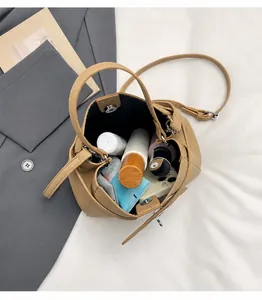 Detail shot of beige bucket bag interior showing spacious capacity and magnetic closure