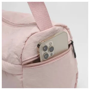 Détail de la poche latérale d'un sac en nylon rose montrant le rangement du portable