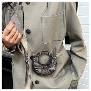 Détail d'un mini sac demi-lune avec texture nervurée métallique et anse ronde