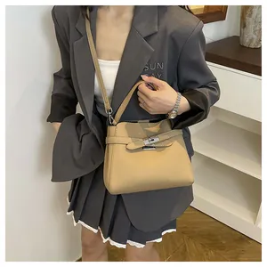 Litchi pattern khaki handbag with metal lock and detachable shoulder strap on a model
