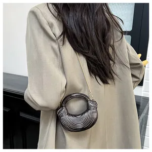 Détail du sac croissant gris métallisé avec texture horizontale et chaîne dorée