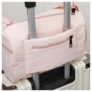 Sac de voyage en nylon rose avec passant pour valise et petite poche zippée à l'arrière
