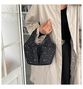 Borsa tote nera con motivo a stelle e fiocco tenuta da una modella in un interno