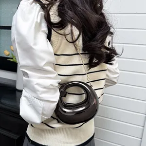 Modern moon-shaped metallic handbag with chain strap and hollow circular handle