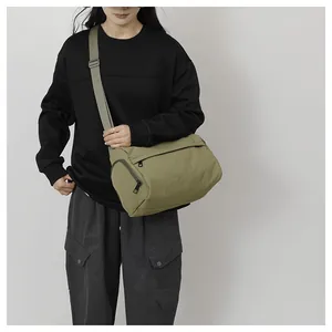 Vue détaillée du sac bandoulière en nylon vert olive avec fermetures éclair en métal