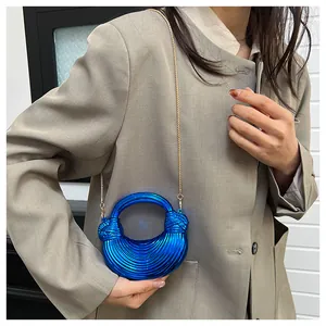 Détail du sac croissant bleu roi métallisé avec nœuds torsadés et chaîne dorée