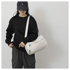 Sac de sport minimaliste en nylon porté par un mannequin avec bandoulière ajustable