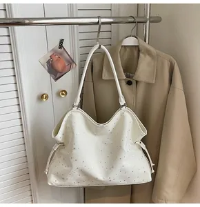 Détail d'un sac cabas blanc avec motif d'étoiles et cordons dans un cadre élégant