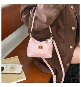 Détail du sac matelassé rose avec fermoir rotatif doré et bandoulière chaîne