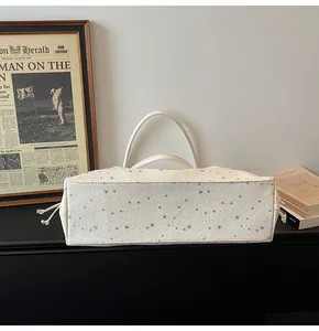 Détails du sac cabas blanc avec motifs d'étoiles, cordon de serrage et poignées élégantes