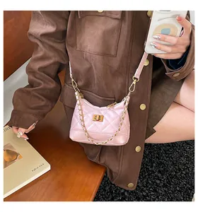 Vue détaillée du sac bandoulière matelassé rose clair avec fermoir rotatif doré et chaîne