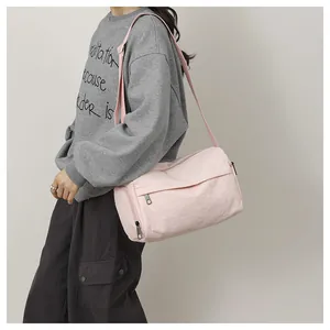 Détail du sac bandoulière cylindrique rose en nylon avec tissu imperméable et sangle
